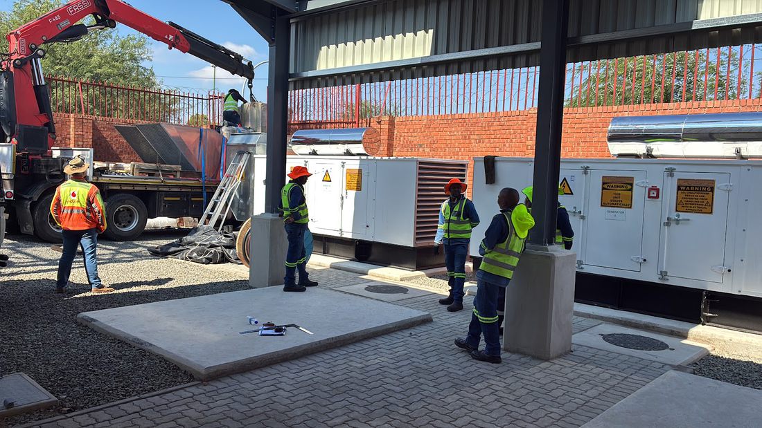 Crane offloading electrical plant on site